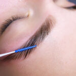 combing the hairs in the eyebrows with a brush after the procedure of coloring and laminating the eyebrows